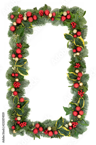 Christmas background border with red and gold bauble decorations, holly, fir, mistletoe and ivy isolated on white background. Festive theme.