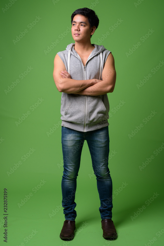 Young handsome Filipino man against green background Young handsome Filipino man against green background