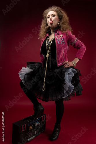 Girl, 1980's style with boom box and bubble gum. red backdrop