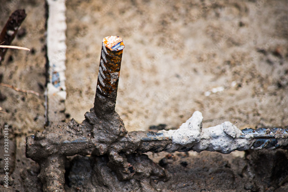 A piece of reinforcement sticks out of concrete A piece of reinforcement sticks out of concrete