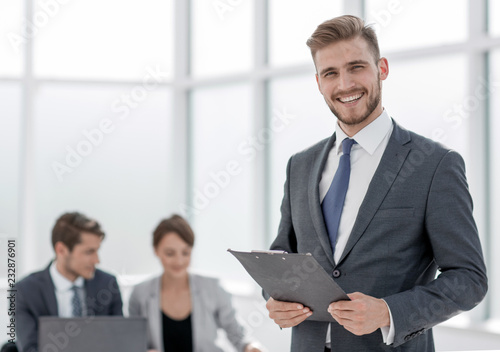 smiling businessman with a clipboard on the background of the of photo