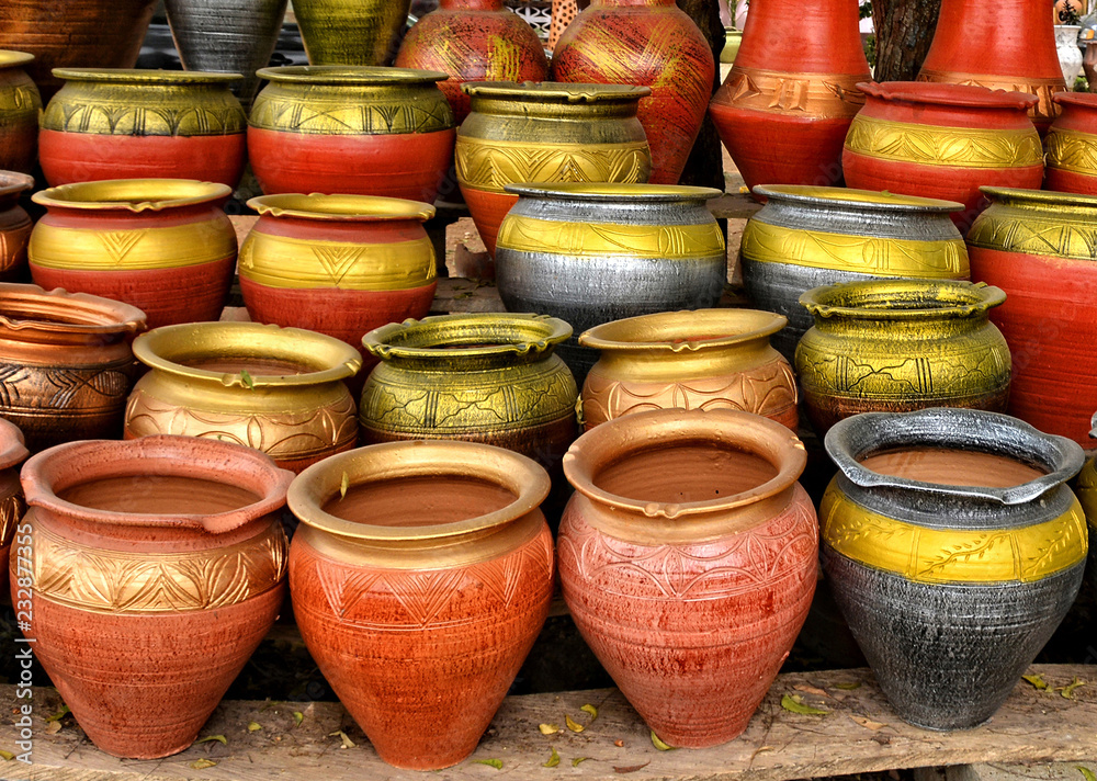 Clay pots stacked for sale on African roads. Pottery making place. Local craft market in Africa. Unique handmade colorful ceramic pots. Craftsmanship. African style.