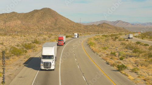 Cars and trucks driving on busy highway, freight semi trucks transporting goods
