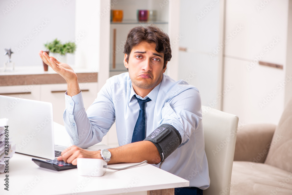 Man under stress measuring his blood pressure Man under stress measuring his blood pressure