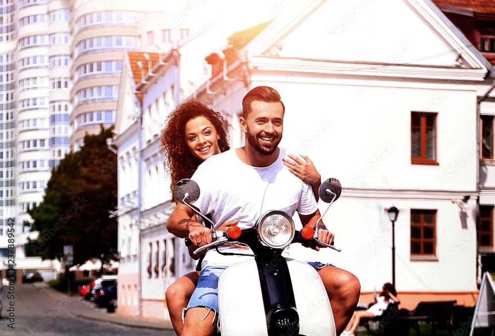 Happy young couple having fun on a scooter