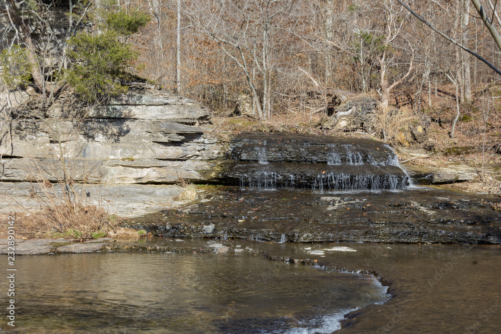 Small waterfall over rocks at the juncture of two streams, winter, horizontal aspect