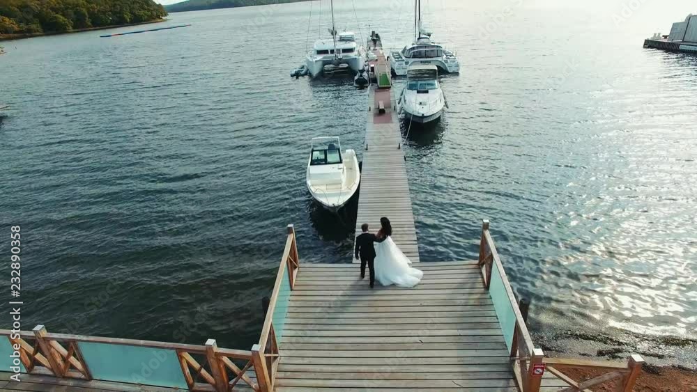 aerial view wedding couple to meet on the pier around sea and yacht aerial view wedding couple to meet on the pier around sea and yacht