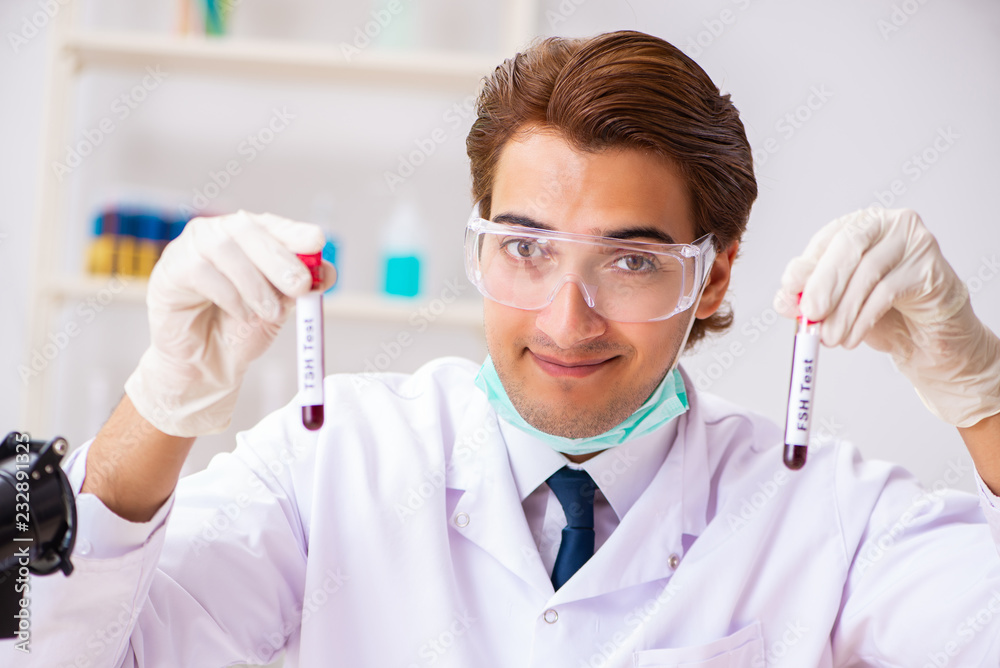 Young handsome lab assistant testing blood samples in hospital Young handsome lab assistant testing blood samples in hospital