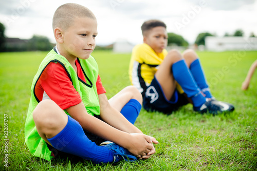 Young football kids stretching on the field