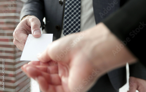 Close-up of two businesspeople exchanging visiting card