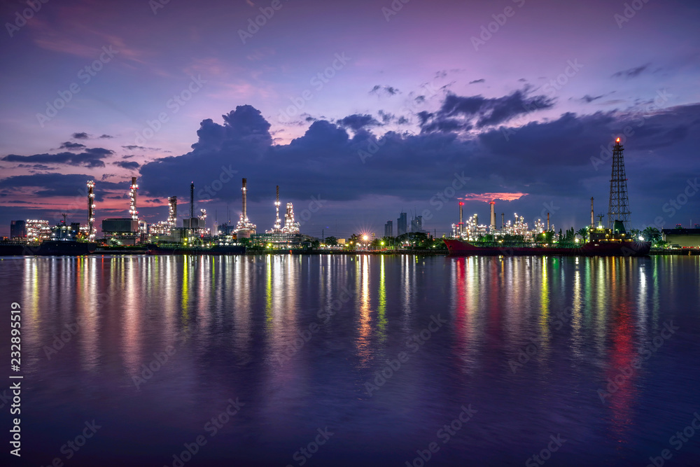 Oil and gas industry - refinery at sunrise - factory - petrochemical plant with reflection over the river Oil and gas industry - refinery at sunrise - factory - petrochemical plant with reflection over the river