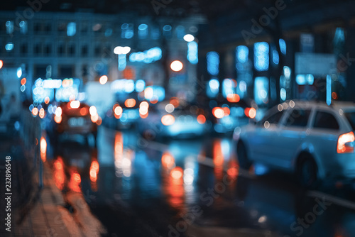 Blurred city at night. Bokeh. Beautiful abstract scene with defocused buildings, cars, city lights, people. Colorful bokeh background with urban night scene. Design. Concept backdrop. Vintage