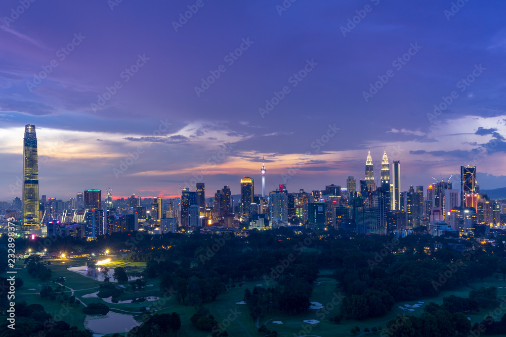 Fototapeta premium Majestatyczny zmierzch nad Kuala Lumpur, kapitał Malezja. Nowoczesna linia horyzontu zdominowana jest przez wysoki na 451 m KLCC, parę szklanych i stalowych wieżowców.