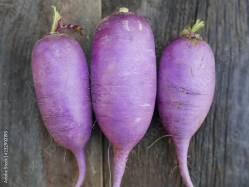 Obraz na płótnie Three purple radishes on a rustic wood table w salonie