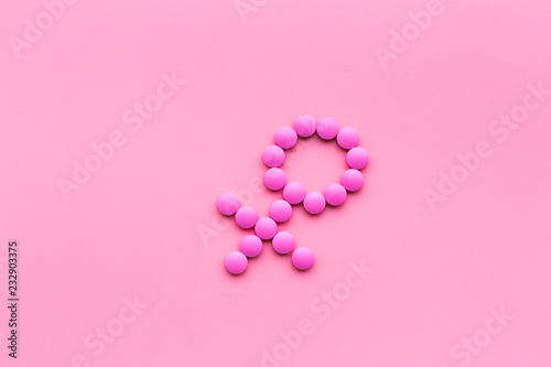 Female diseases. Female gender icon symbol made of pills on pink background top view space for text