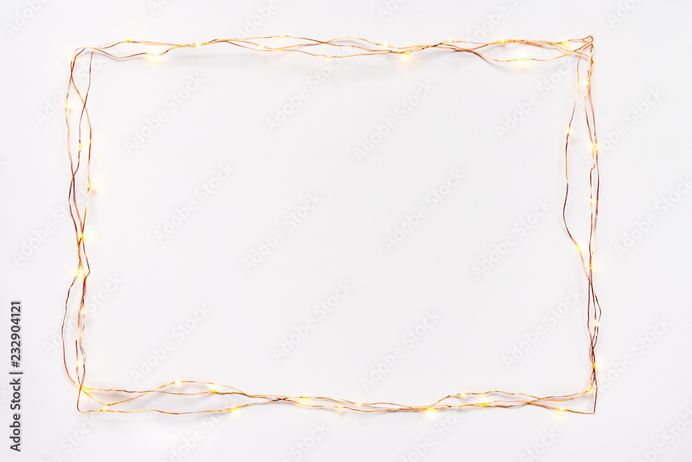 Christmas lights garland border over white background. Flat lay, copy space.