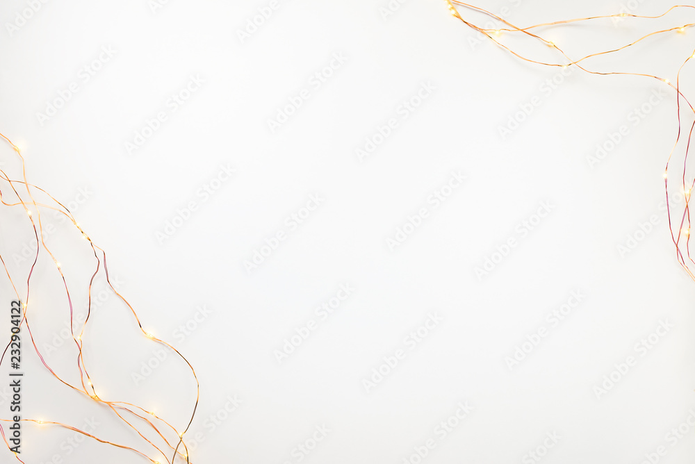 Christmas lights garland border over white background. Flat lay, copy space.