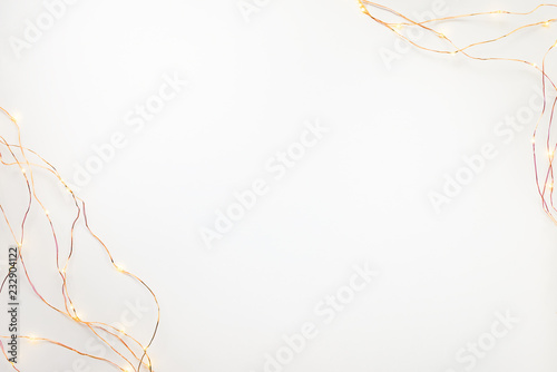 Obraz na płótnie Christmas lights garland border over white background. Flat lay, copy space. w salonie