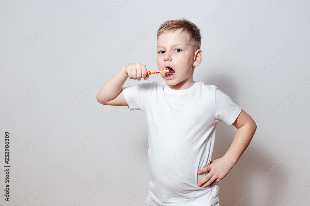 six-year-old boy brushing his teeth on a white background six-year-old boy brushing his teeth on a white background