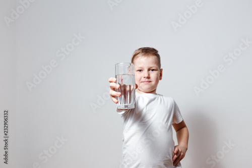 happy cute boy in white t-shirt holding a glass glass glass glass of drinking water