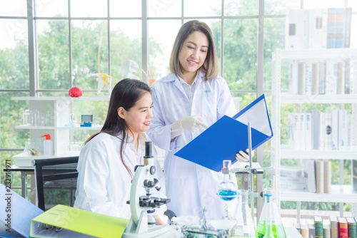 Two of asian female scientists in white coat working at the laboratory