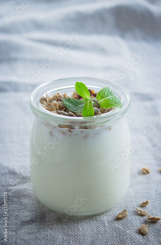 Homemade granola with greak yogurt in a glass jar. Healthy food concept