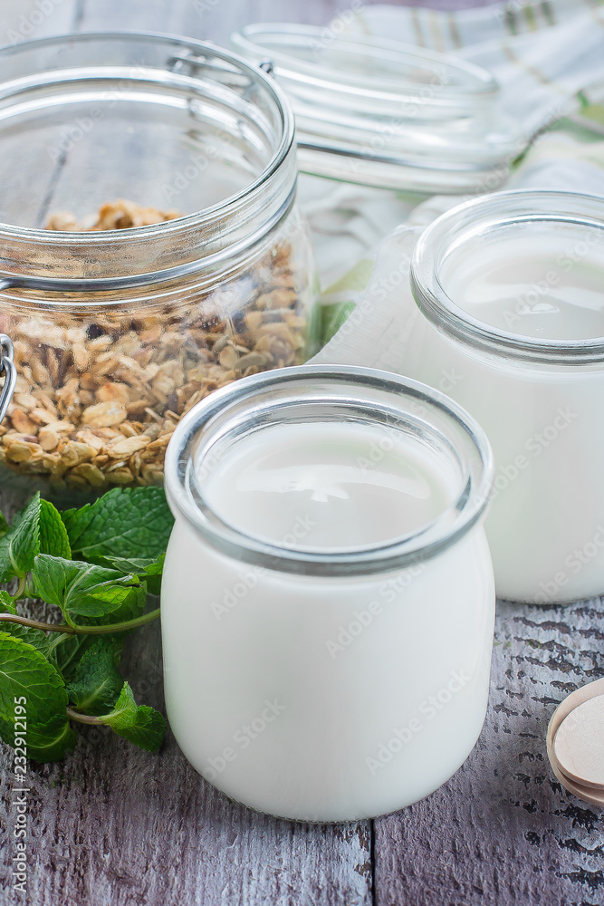 Two glass jarы with greek yogurt and jar with homemade oat granola for healthy breakfast Two glass jarы with greek yogurt and jar with homemade oat granola for healthy breakfast