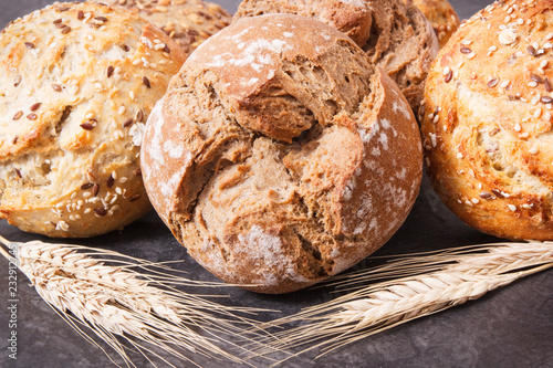 Wholegrain crunchy rolls for breakfast and ears of rye or wheat grain