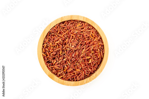 Red rice  shot from the top in a wooden bowl on a white background with a place for text