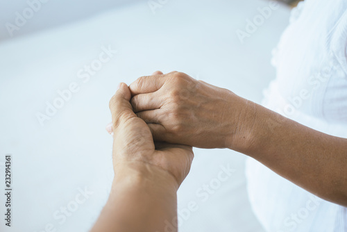 Man giving hand to depressed elderly woman Psychiatrist holding hands patient Mental health care concept
