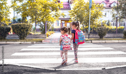 Vászonkép Children go to school, happy students with school backpacks and holding hands to