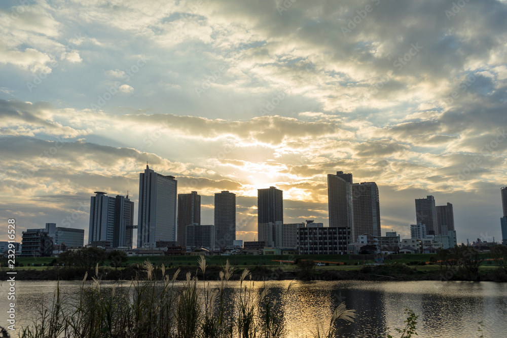 the sun sets in the buildings across the Tama River Kawasaki Kanagawa Japan the sun sets in the buildings across the Tama River Kawasaki Kanagawa Japan