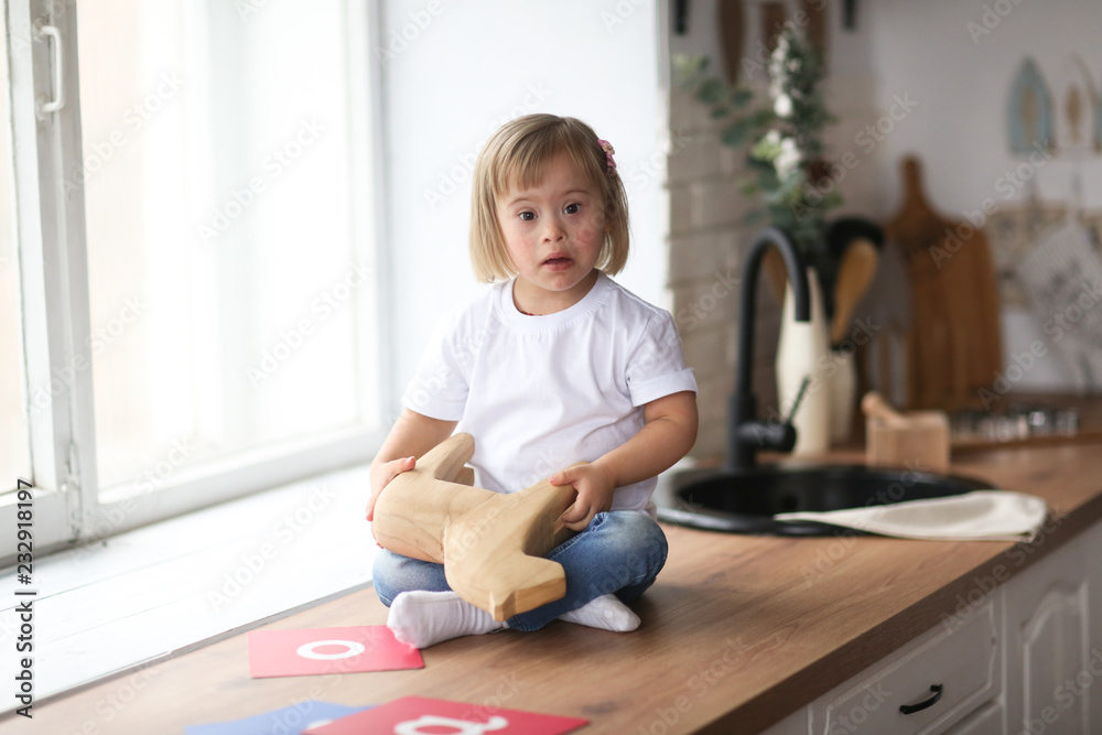 Toddler with Down syndrome plays with wooden horse Toddler with Down syndrome plays with wooden horse