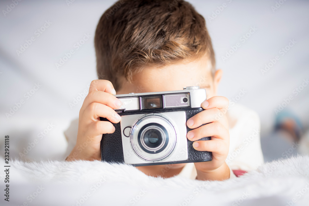 Beautiful boy with a photographing camera in the bed Beautiful boy with a photographing camera in the bed