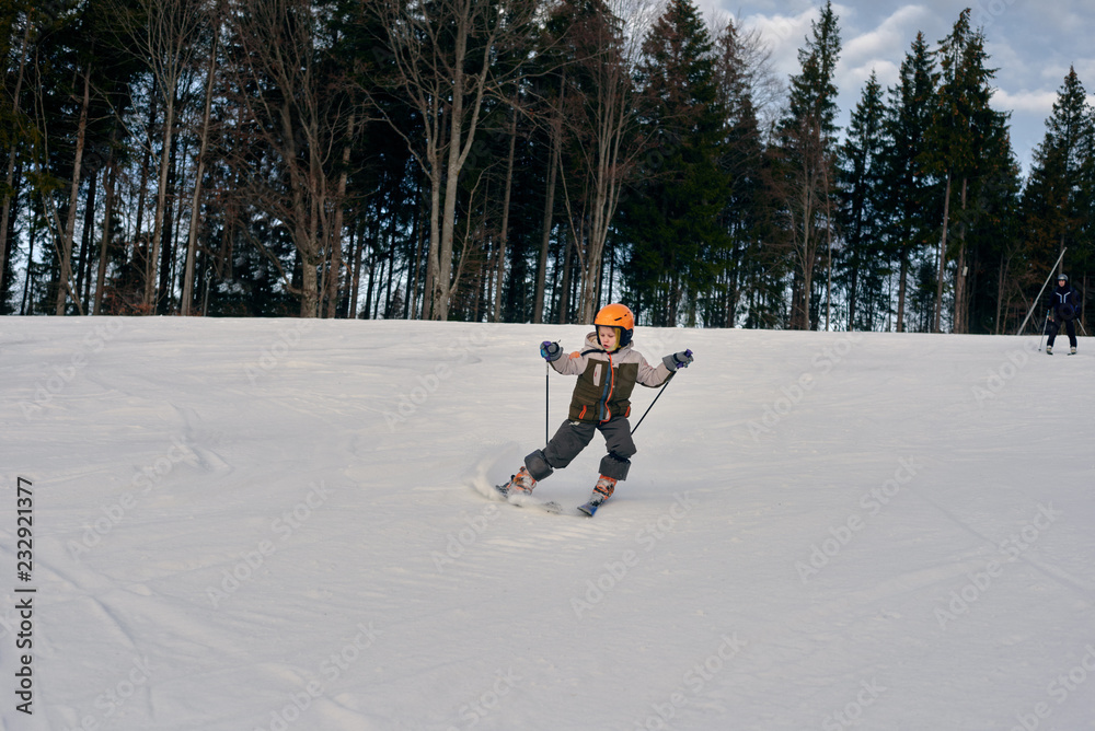 Active young boy skiing in mountains and enjoying vacation