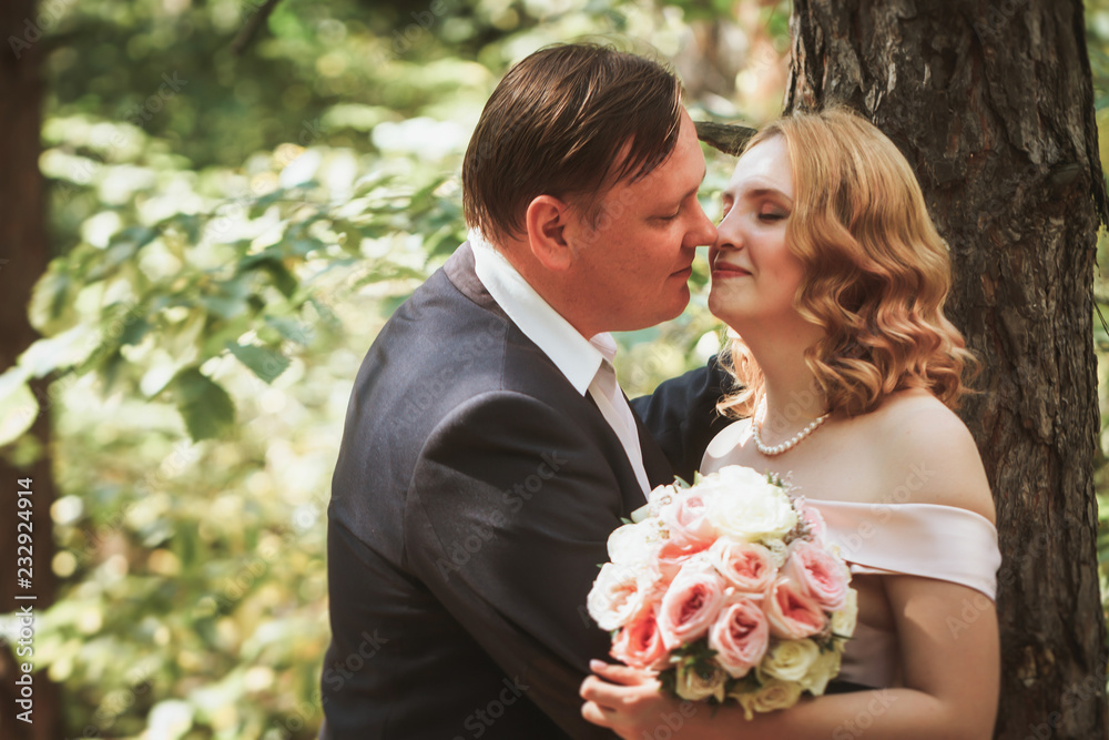 bride and groom kiss on the background of trees and forest bride and groom kiss on the background of trees and forest