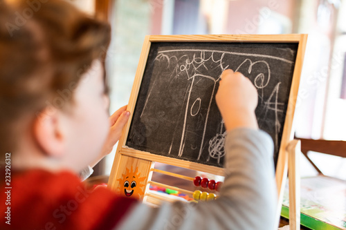 Obraz na plátně Bambina che disegna sulla lavagna divertendosi