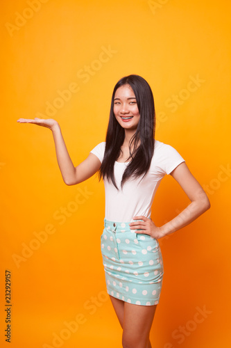 Young Asian woman present with her hand.
