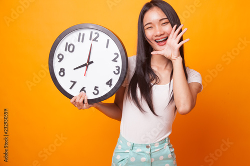 Happy Young Asian woman with a clock.