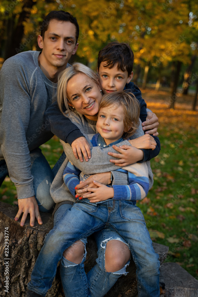 Smiling young family into leaves on an autumns day Smiling young family into leaves on an autumns day