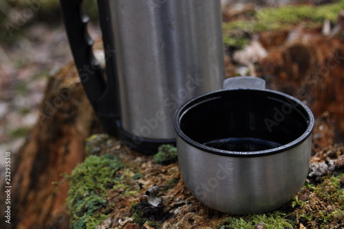 Hot tea in thermos for a walk in the woods while resting