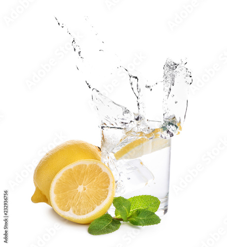 Glass of water with lemon and mint on white background