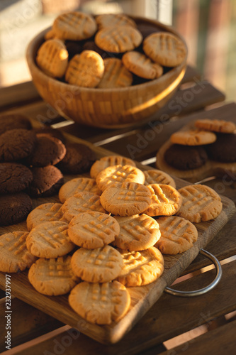 Peanut and chocolate cookies on wooden background in sun rays