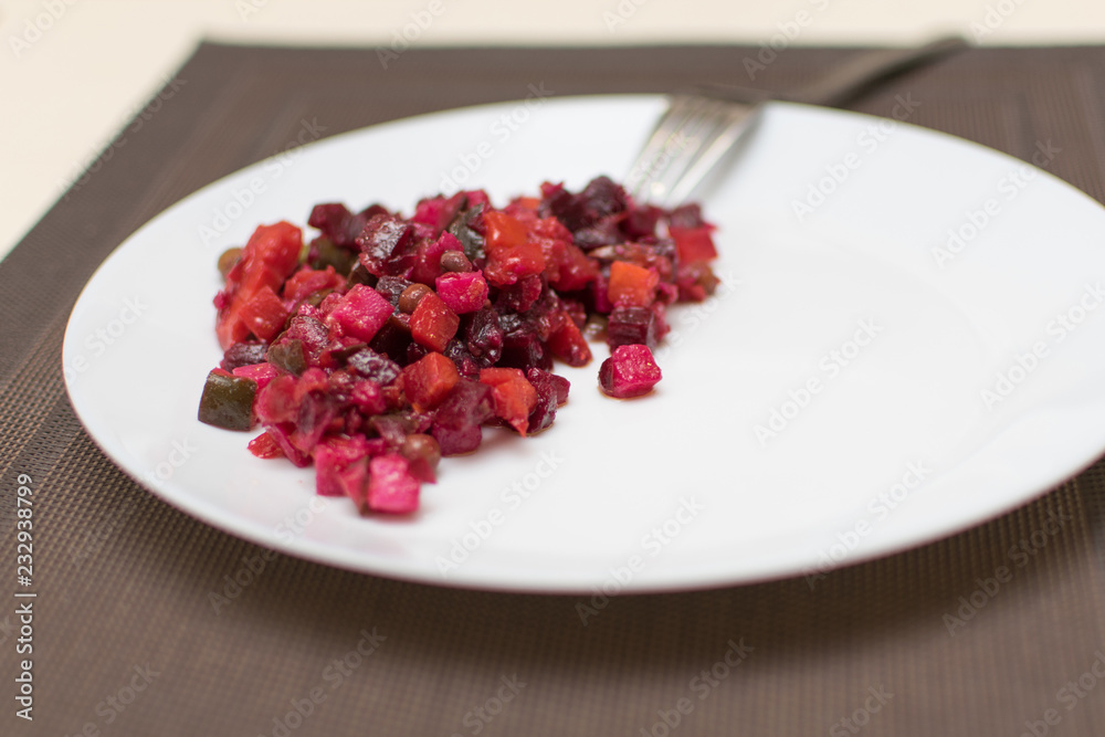 Vinaigrette salad of beet, carrots, peas, onions, potatoes on a white plate. Vinaigrette salad of beet, carrots, peas, onions, potatoes on a white plate.