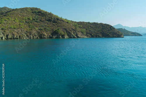 Overgrown mountains on the island. seascape background. water surface in a bay