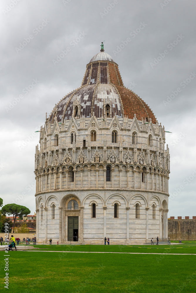 PISA, ITALY - OCTOBER 29, 2018: Baptistery in famous Piazza del Duomo (Piazza dei Miracoli) in Pisa. Unesco World Heritage Site.