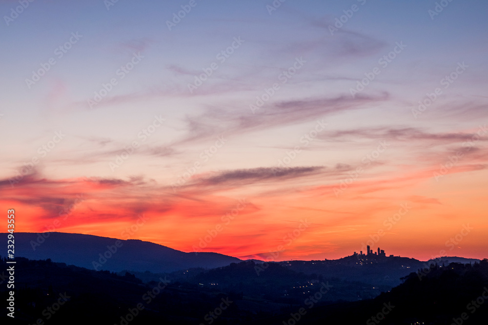 Amazing coloured sunset in Tuscany Italy with red clouds and blue ground during the blue hours. Beautiful landscape with colors and feeling