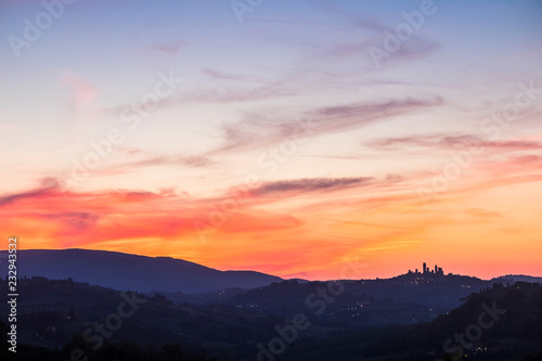 San Gimignano Tuscany view after a great coloured sunset in the beautiful wine valley in Italy. Colors red and blue and ancient town tower in silhouette