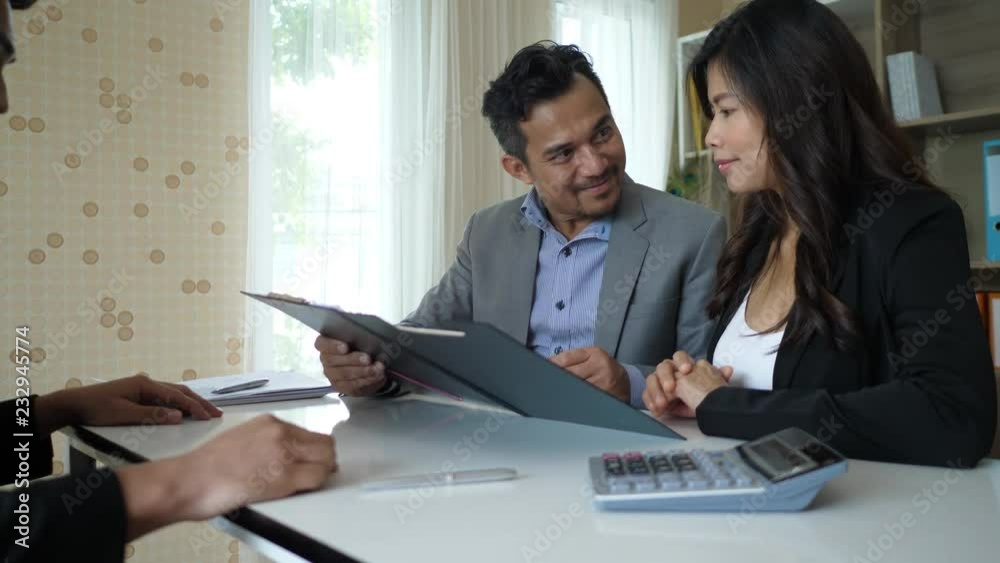 Happy couple sit talking and invest their business affairs with business planner Happy couple sit talking and invest their business affairs with business planner