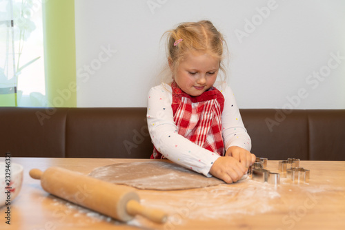 süßes Kind beim Kekse ausstechen